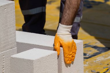 Tuğlacı çalışıyor. Havalandırmalı betondan bir duvar inşa etmek. Gasbeton duvarı
