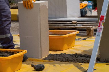 Tuğlacı çalışıyor. Havalandırmalı betondan bir duvar inşa etmek. Gasbeton duvarı