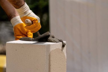 Tuğlacı çalışıyor. Havalandırmalı betondan bir duvar inşa etmek. Gasbeton duvarı