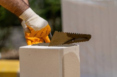Tuğlacı çalışıyor. Havalandırmalı betondan bir duvar inşa etmek. Gasbeton duvarı