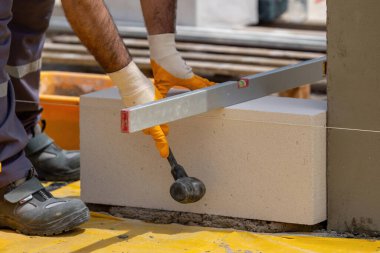 Tuğlacı çalışıyor. Havalandırmalı betondan bir duvar inşa etmek. Gasbeton duvarı