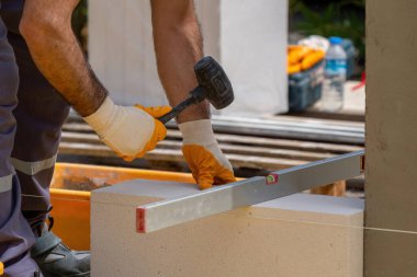 Tuğlacı çalışıyor. Havalandırmalı betondan bir duvar inşa etmek. Gasbeton duvarı