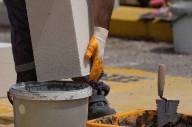 Tuğlacı çalışıyor. Havalandırmalı betondan bir duvar inşa etmek. Gasbeton duvarı