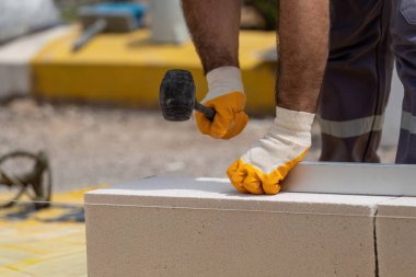 Tuğlacı çalışıyor. Havalandırmalı betondan bir duvar inşa etmek. Gasbeton duvarı