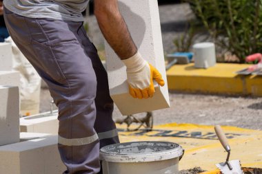 Tuğlacı çalışıyor. Havalandırmalı betondan bir duvar inşa etmek. Gasbeton duvarı