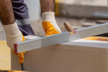 Tuğlacı çalışıyor. Havalandırmalı betondan bir duvar inşa etmek. Gasbeton duvarı