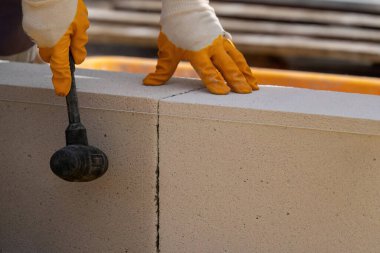 Tuğlacı çalışıyor. Havalandırmalı betondan bir duvar inşa etmek. Gasbeton duvarı