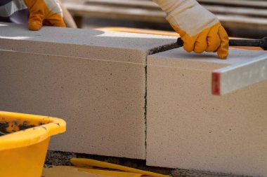 Tuğlacı çalışıyor. Havalandırmalı betondan bir duvar inşa etmek. Gasbeton duvarı