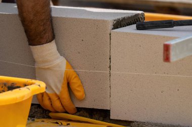 Tuğlacı çalışıyor. Havalandırmalı betondan bir duvar inşa etmek. Gasbeton duvarı