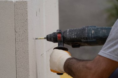 Tuğlacı çalışıyor. Havalandırmalı betondan bir duvar inşa etmek. Gasbeton duvarı