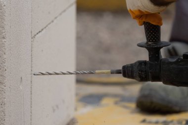 Tuğlacı çalışıyor. Havalandırmalı betondan bir duvar inşa etmek. Gasbeton duvarı
