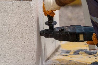 Tuğlacı çalışıyor. Havalandırmalı betondan bir duvar inşa etmek. Gasbeton duvarı