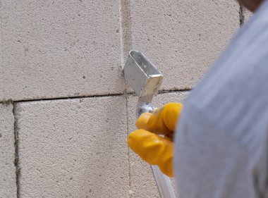 Tuğlacı çalışıyor. Havalandırmalı betondan bir duvar inşa etmek. Gasbeton duvarı