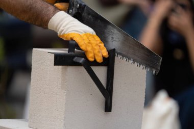 Tuğlacı çalışıyor. Havalandırmalı betondan bir duvar inşa etmek. Gasbeton duvarı