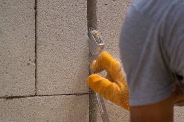 Tuğlacı çalışıyor. Havalandırmalı betondan bir duvar inşa etmek. Gasbeton duvarı