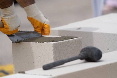 Tuğlacı çalışıyor. Havalandırmalı betondan bir duvar inşa etmek. Gasbeton duvarı