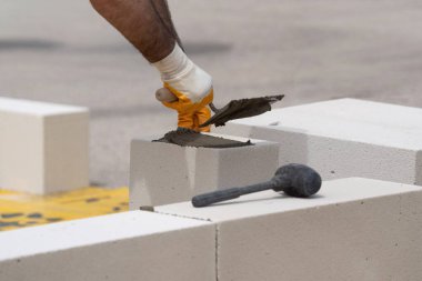 Tuğlacı çalışıyor. Havalandırmalı betondan bir duvar inşa etmek. Gasbeton duvarı