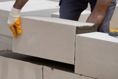 Tuğlacı çalışıyor. Havalandırmalı betondan bir duvar inşa etmek. Gasbeton duvarı