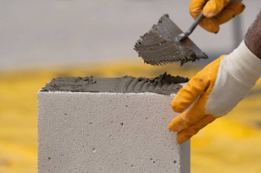 Tuğlacı çalışıyor. Havalandırmalı betondan bir duvar inşa etmek. Gasbeton duvarı