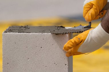 Tuğlacı çalışıyor. Havalandırmalı betondan bir duvar inşa etmek. Gasbeton duvarı