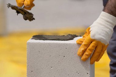 Tuğlacı çalışıyor. Havalandırmalı betondan bir duvar inşa etmek. Gasbeton duvarı