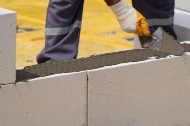 Tuğlacı çalışıyor. Havalandırmalı betondan bir duvar inşa etmek. Gasbeton duvarı