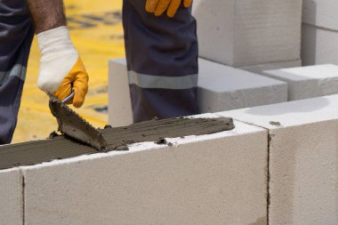 Tuğlacı çalışıyor. Havalandırmalı betondan bir duvar inşa etmek. Gasbeton duvarı