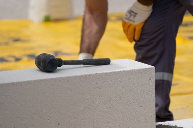 Tuğlacı çalışıyor. Havalandırmalı betondan bir duvar inşa etmek. Gasbeton duvarı