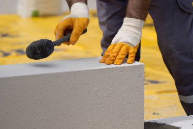 Tuğlacı çalışıyor. Havalandırmalı betondan bir duvar inşa etmek. Gasbeton duvarı