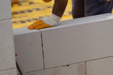 Tuğlacı çalışıyor. Havalandırmalı betondan bir duvar inşa etmek. Gasbeton duvarı