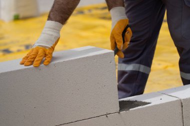 Tuğlacı çalışıyor. Havalandırmalı betondan bir duvar inşa etmek. Gasbeton duvarı