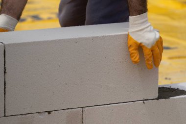 Tuğlacı çalışıyor. Havalandırmalı betondan bir duvar inşa etmek. Gasbeton duvarı