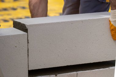 Tuğlacı çalışıyor. Havalandırmalı betondan bir duvar inşa etmek. Gasbeton duvarı