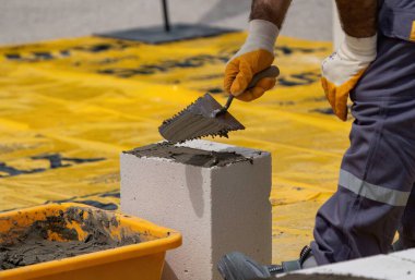 Tuğlacı çalışıyor. Havalandırmalı betondan bir duvar inşa etmek. Gasbeton duvarı