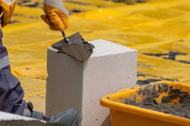 Tuğlacı çalışıyor. Havalandırmalı betondan bir duvar inşa etmek. Gasbeton duvarı