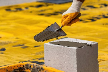 Tuğlacı çalışıyor. Havalandırmalı betondan bir duvar inşa etmek. Gasbeton duvarı