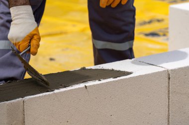 Tuğlacı çalışıyor. Havalandırmalı betondan bir duvar inşa etmek. Gasbeton duvarı