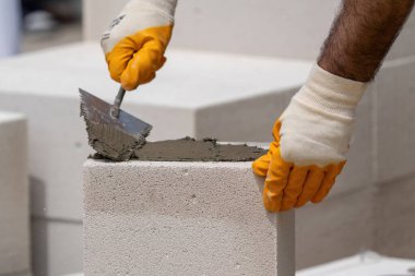 Tuğlacı çalışıyor. Havalandırmalı betondan bir duvar inşa etmek. Gasbeton duvarı