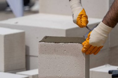 Tuğlacı çalışıyor. Havalandırmalı betondan bir duvar inşa etmek. Gasbeton duvarı