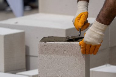 Tuğlacı çalışıyor. Havalandırmalı betondan bir duvar inşa etmek. Gasbeton duvarı