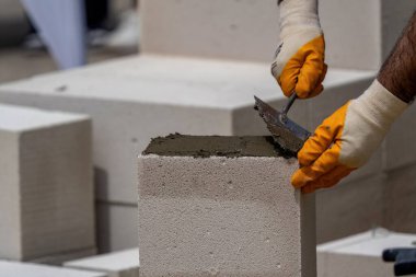 Tuğlacı çalışıyor. Havalandırmalı betondan bir duvar inşa etmek. Gasbeton duvarı