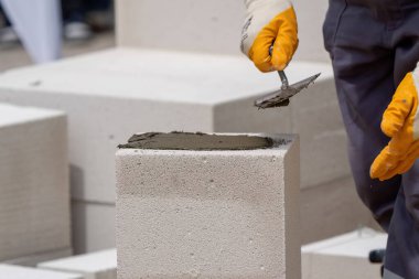 Tuğlacı çalışıyor. Havalandırmalı betondan bir duvar inşa etmek. Gasbeton duvarı