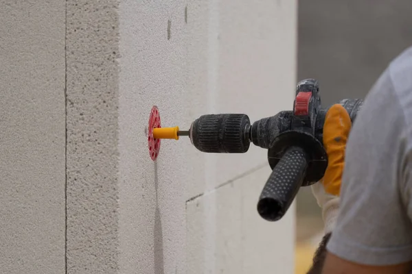 Tuğlacı çalışıyor. Havalandırmalı betondan bir duvar inşa etmek. Gasbeton duvarı