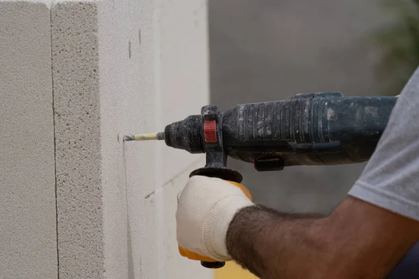 Tuğlacı çalışıyor. Havalandırmalı betondan bir duvar inşa etmek. Gasbeton duvarı