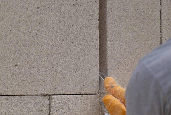 Tuğlacı çalışıyor. Havalandırmalı betondan bir duvar inşa etmek. Gasbeton duvarı