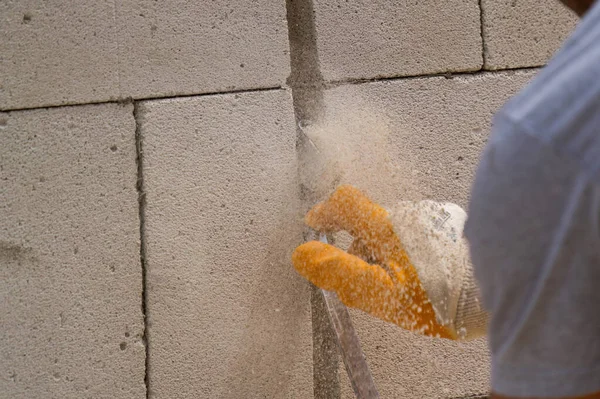 Tuğlacı çalışıyor. Havalandırmalı betondan bir duvar inşa etmek. Gasbeton duvarı