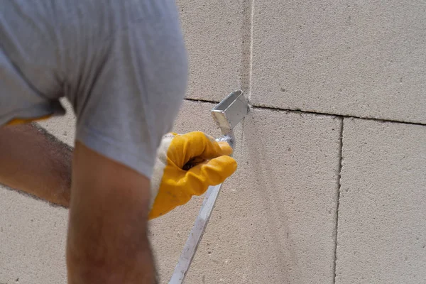 Tuğlacı çalışıyor. Havalandırmalı betondan bir duvar inşa etmek. Gasbeton duvarı