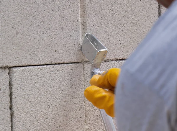 Tuğlacı çalışıyor. Havalandırmalı betondan bir duvar inşa etmek. Gasbeton duvarı