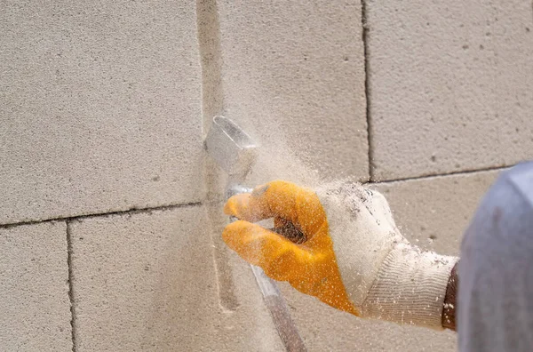 Tuğlacı çalışıyor. Havalandırmalı betondan bir duvar inşa etmek. Gasbeton duvarı