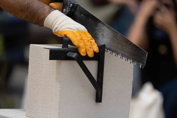 Tuğlacı çalışıyor. Havalandırmalı betondan bir duvar inşa etmek. Gasbeton duvarı